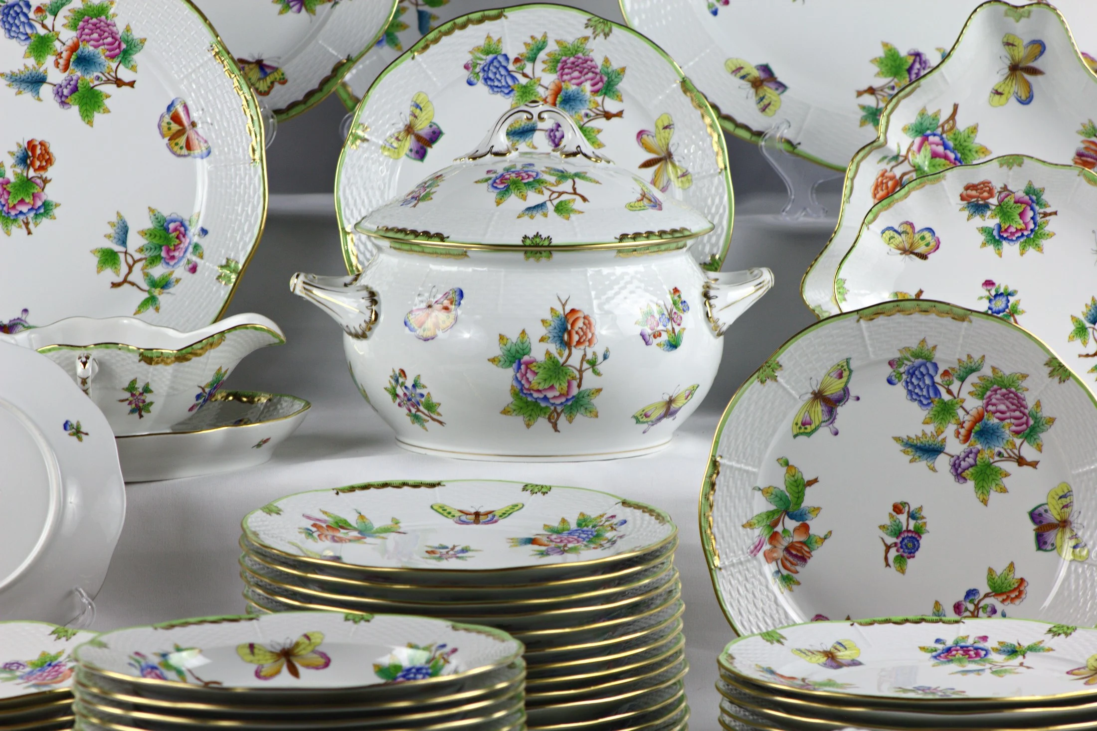 Zuppiera, piatti e complementi del servizio Herend Queen Victoria, con decoro di fiori e farfalle.