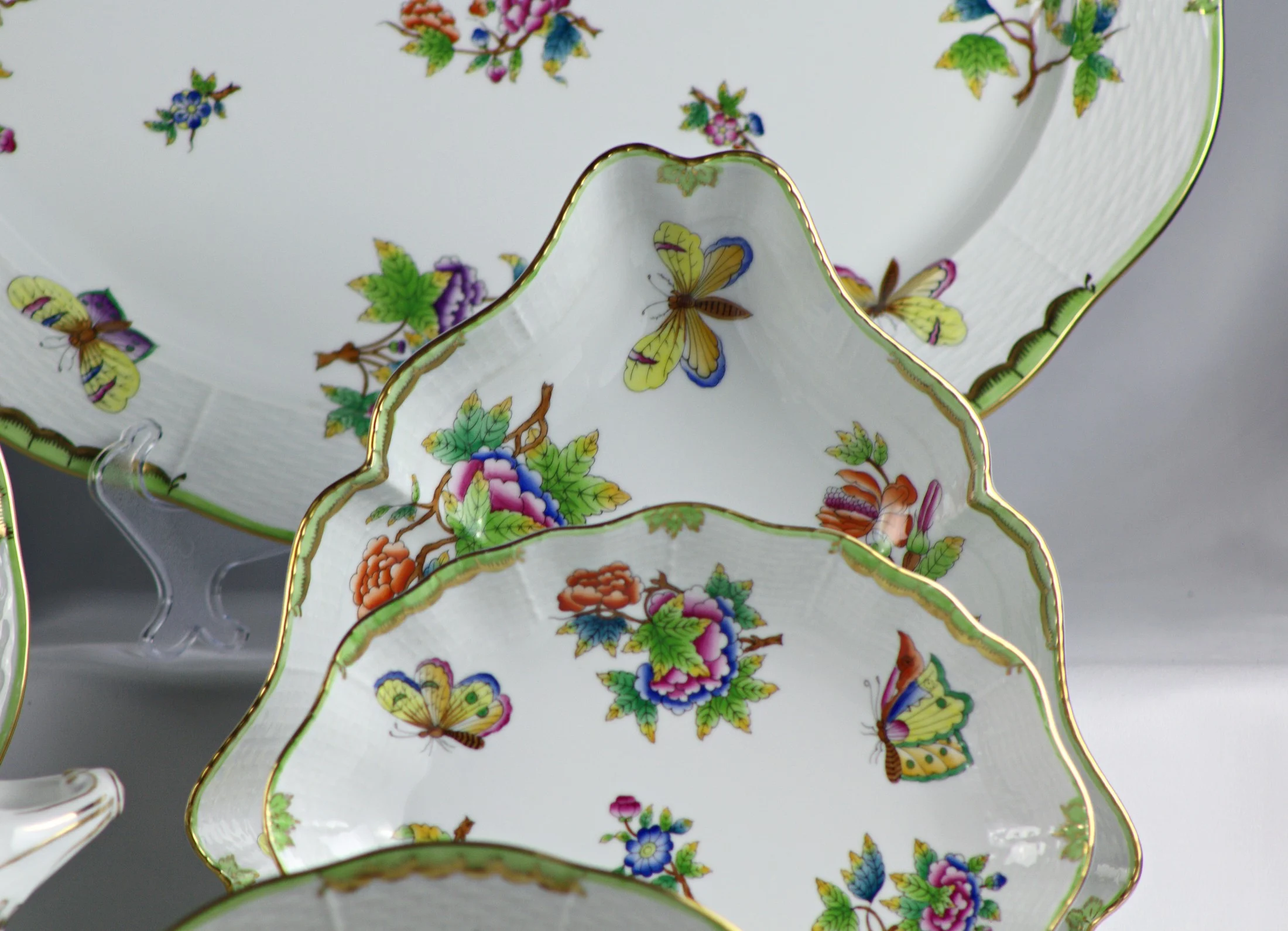 Piatti sagomati con fiori e farfalle del servizio Herend Queen Victoria, con decoro di fiori e farfalle.
